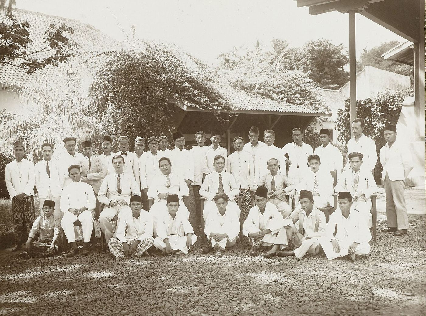 Pegawai bagian pertanian Centraal Kantoor voor de Statistiek berfoto bersama, sebagian berpeci dan bersarung, 1935